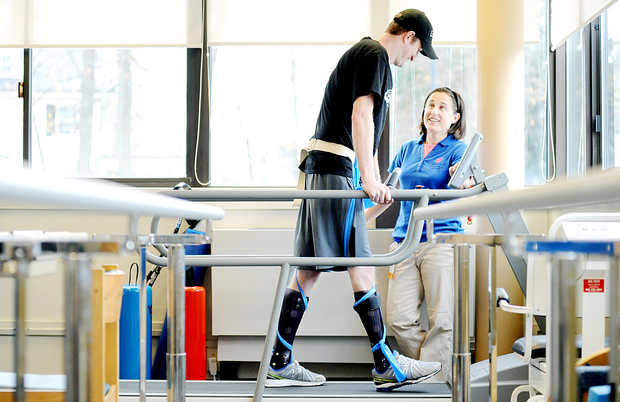 Nate Clark of Dixfield works with his physical therapist, Sophie Herr, at the New England Rehabilitation Hospital of Portland. Clark suffered a spinal cord injury during a snowmobile hill climb race at Black Mountain ski area on Jan. 11. He is able to use his legs, but not nearly to the extent that he could before the accident. "Nate has to teach his brain to use his legs in a different way," Herr said. Clark has physical therapy once a week.